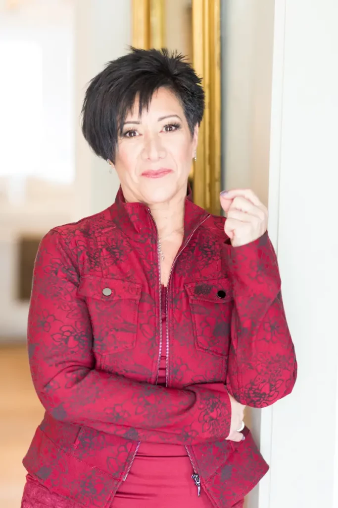 Barbara Alexander standing in doorway in red jacket